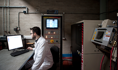 Male researcher working on computer in Dalton Nuclear Institute laboratory
