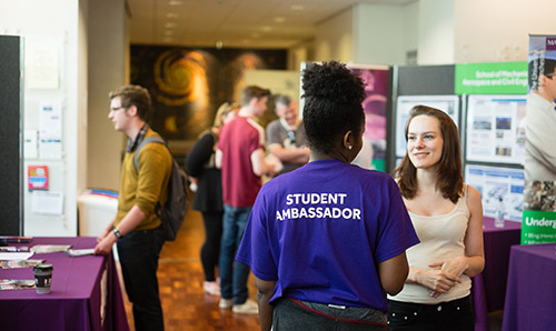 Student ambassador helping out a visitor on an open day