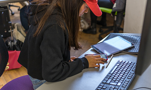 Female student using a mobile phone and tablet 