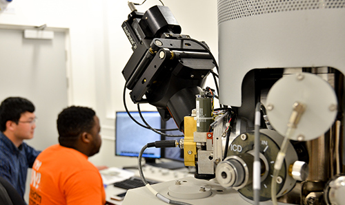 Male students using computer equipment in the EM Centre