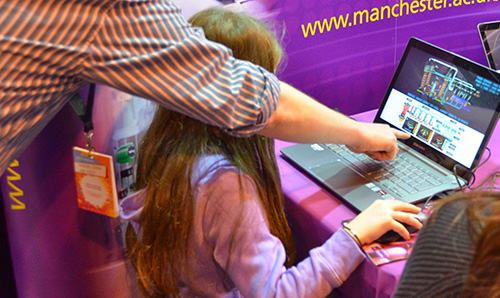 University lecturer showing a young girl how to use a computer