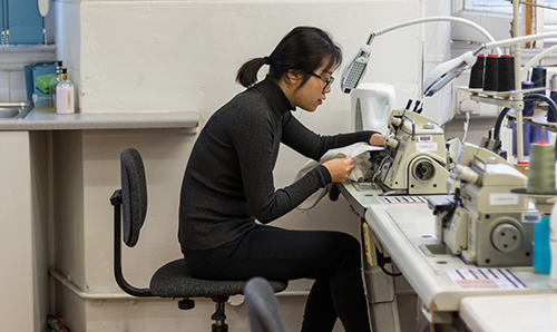 Female student operating a sewing machine