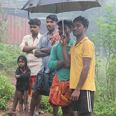 Men and children stood in the rain in Kerala, India