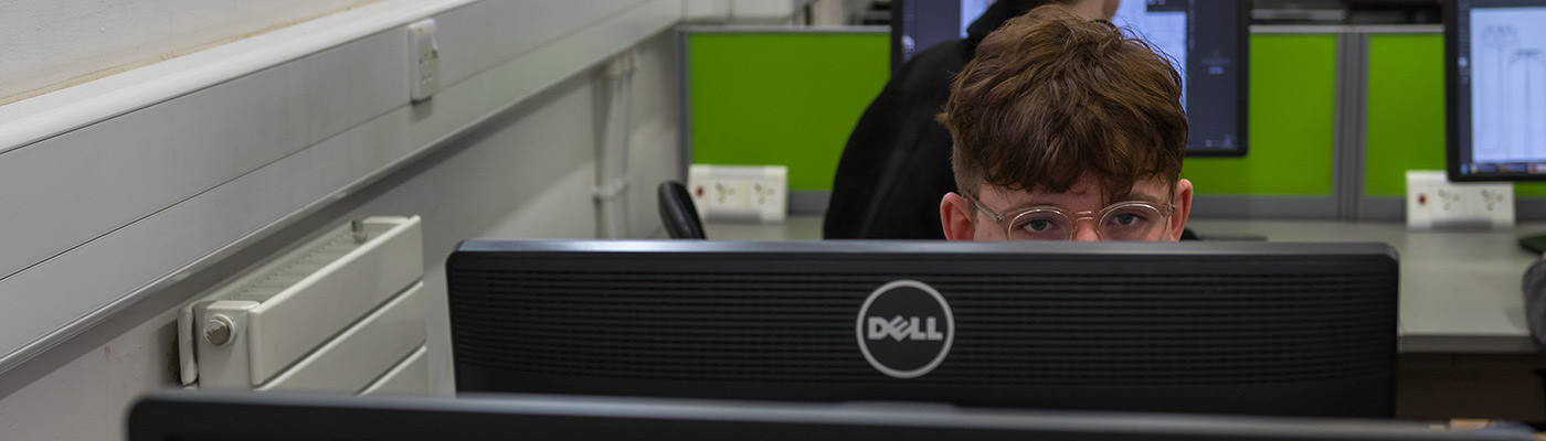 Male student with glasses using a computer