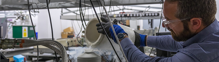 Researcher pouring liquid in the Photon Science Institute