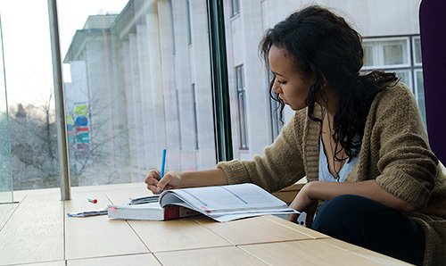 researcher writing at at desk