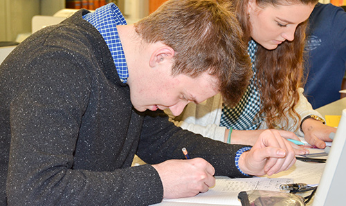 A male student writing in a classroom